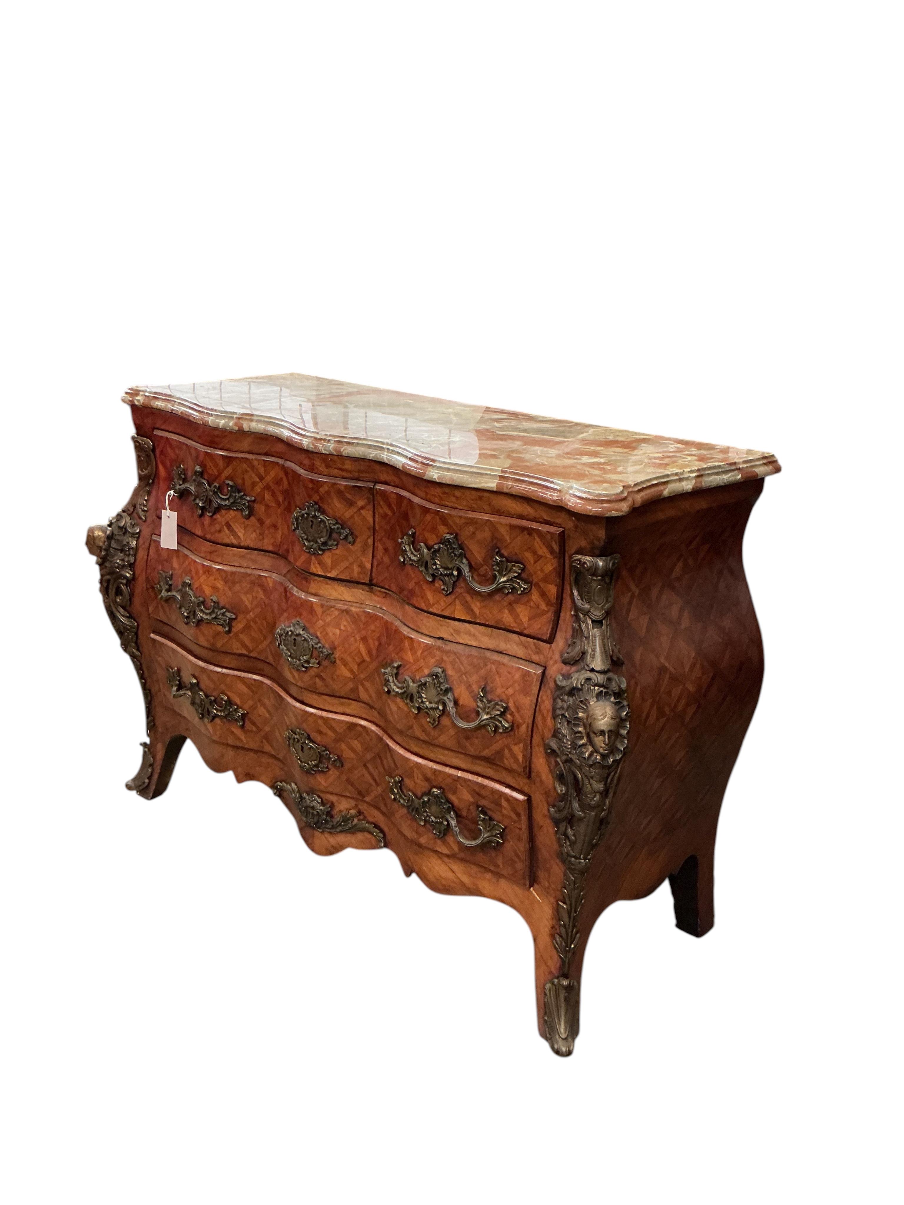 A French transitional style gilt metal mounted onyx top bombe commode, width 114cm, depth 47cm, height 88cm
